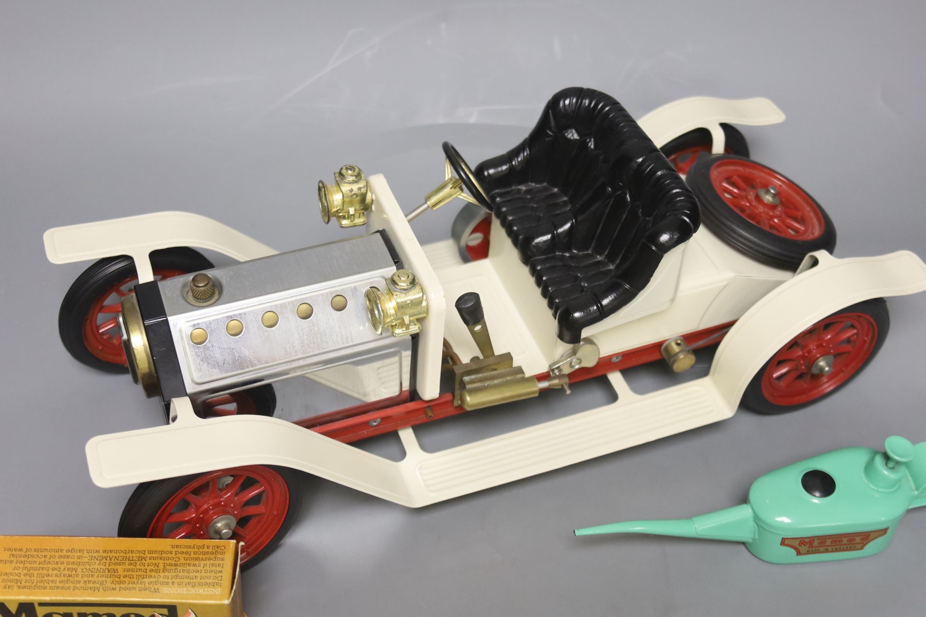 A Mamod live steam vintage two-seater roadster, with silver and cream paintwork and red wheels, oil can